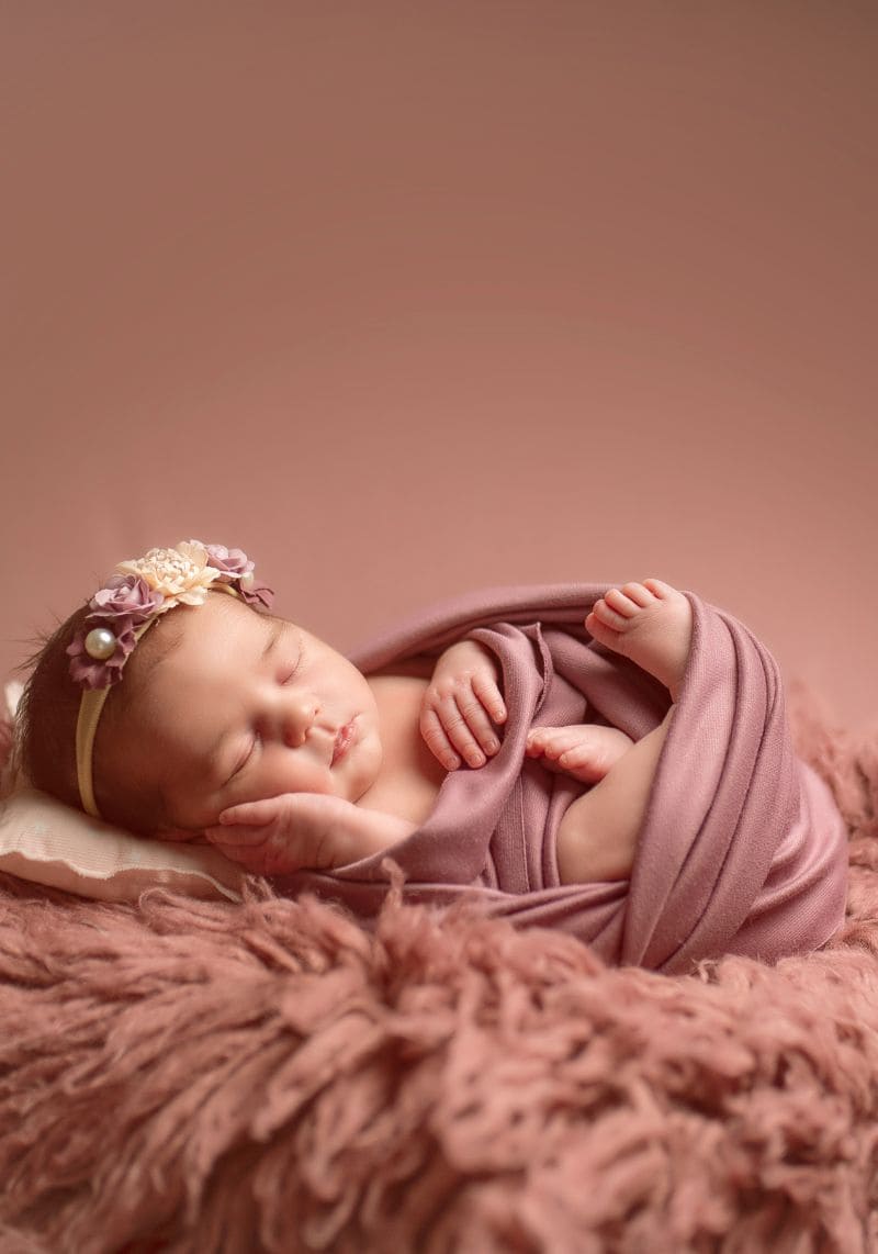 Foto bebé recién nacido con fondo rosa en un sesión de fotos de Alejandra Mato Fotografía