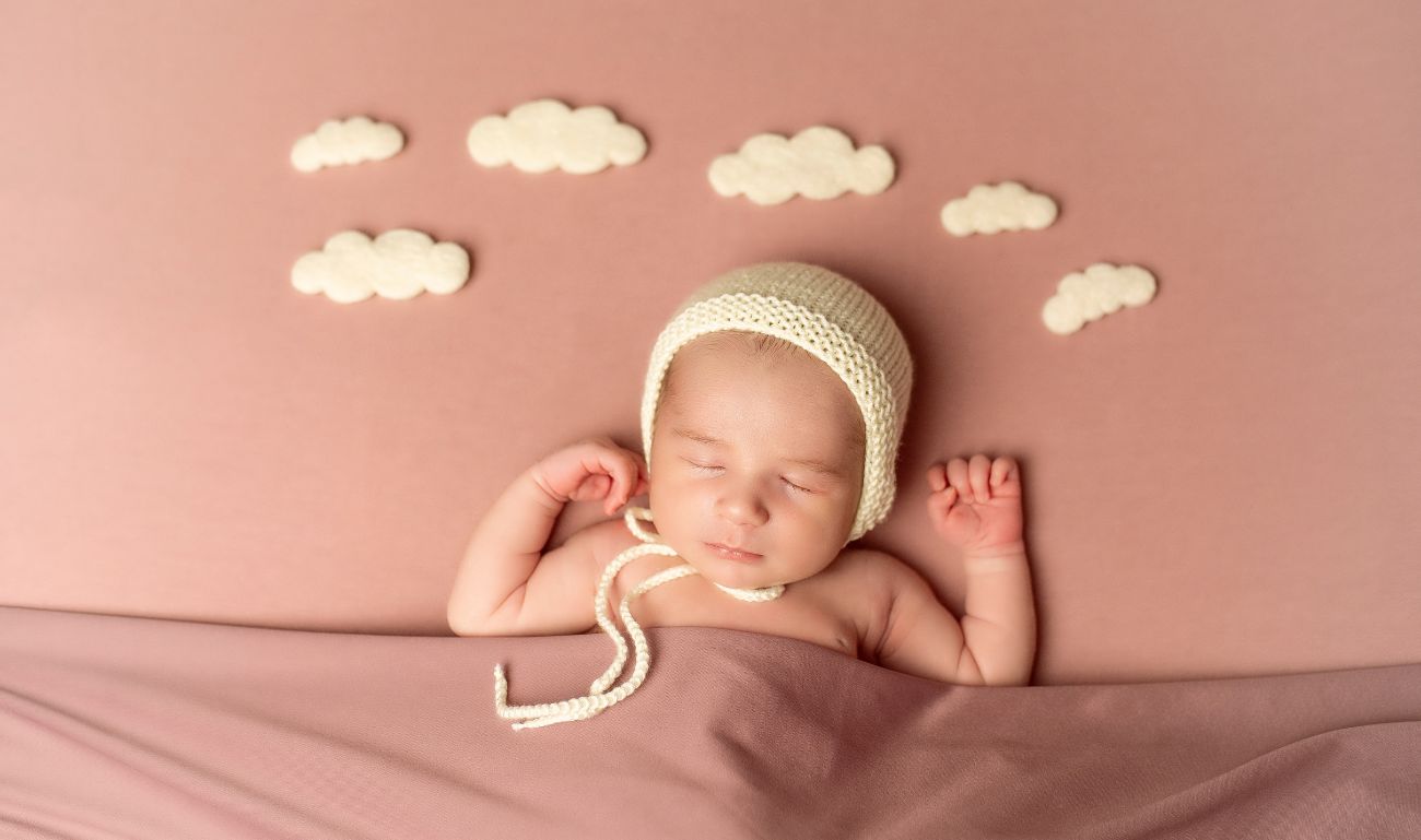 Foto bebé recién nacido con fondo rosa en un sesión de fotos de Alejandra Mato Fotografía